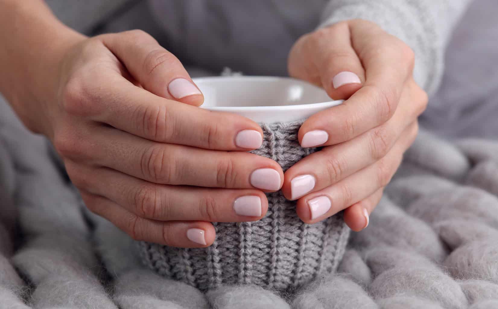 woman-drinking-hot-drink-from-cozy-mug-close-up-warmth-concept