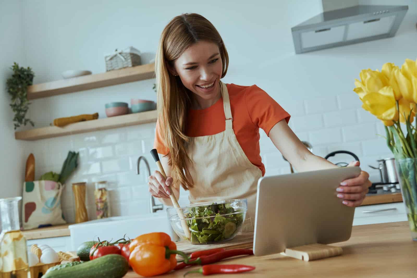 confident-young-woman-cooking-and-using-digital-tablet