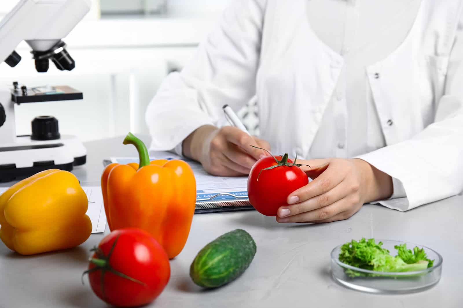 scientist-with-fresh-vegetables-and-clipboard-at-table-in-laboratory-closeup-poison-detection