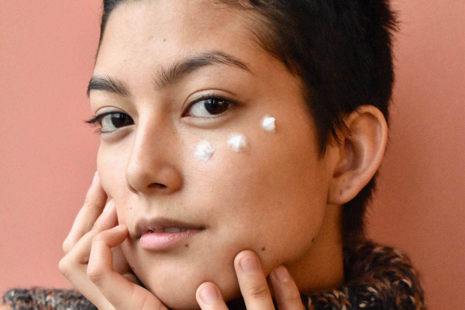 Woman with cream on face - sunscreen skin care concept for melasma and hyperpigmentation prone skin of colour