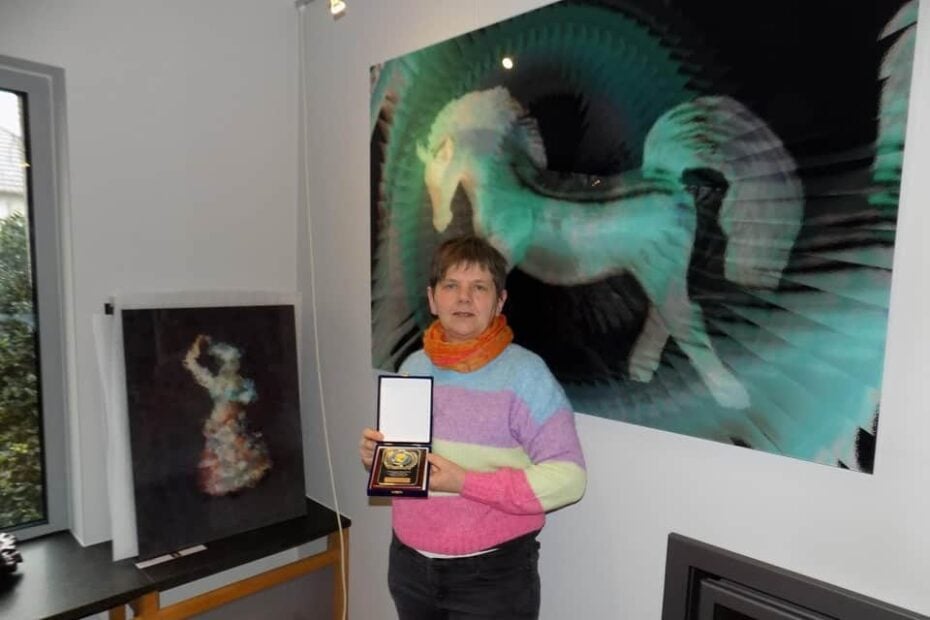 Kunstenares Anita Fleerackers uit Gierle toont haar gouden medaille bij twee van haar bekroonde digitale kunstwerken, Crazy Horse en Fun. — Foto © Bart Van den Langenbergh