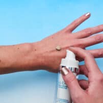 All Calm liquid mineral cream treatment with SPF showing shade colour on hand