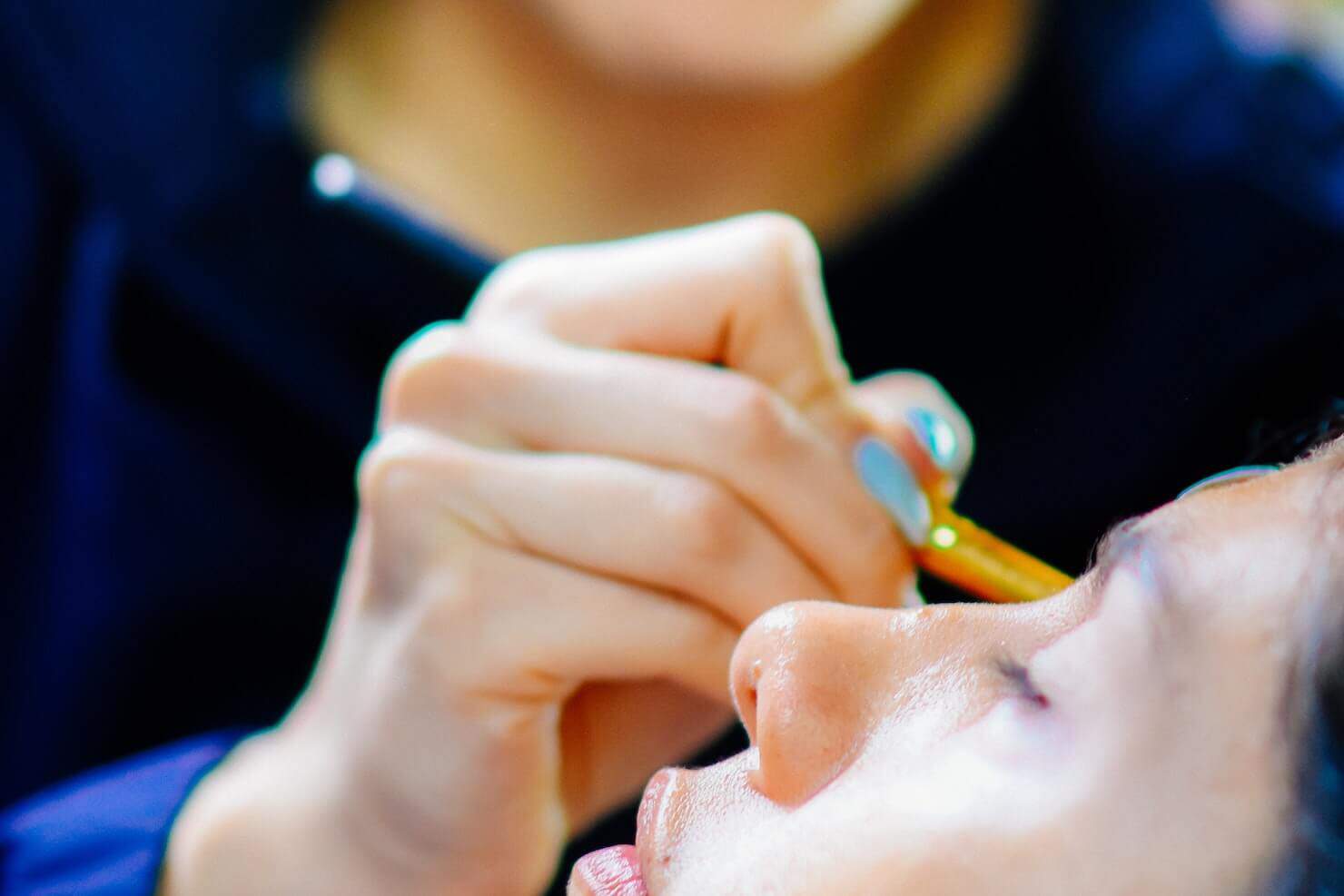 makeup artist drawing eyebrows with brush