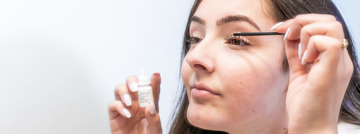 woman applying latisse eyelash growth serum to eyes