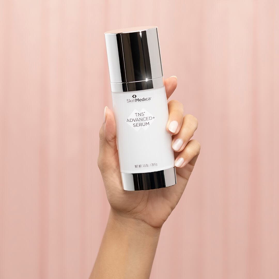 SkinMedica TNS Advanced+ Serum dual chamber growth factor product - hand holding bottle showing size