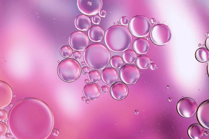 Closeup of bubbles on a pink background - depicting hyaluronic acid