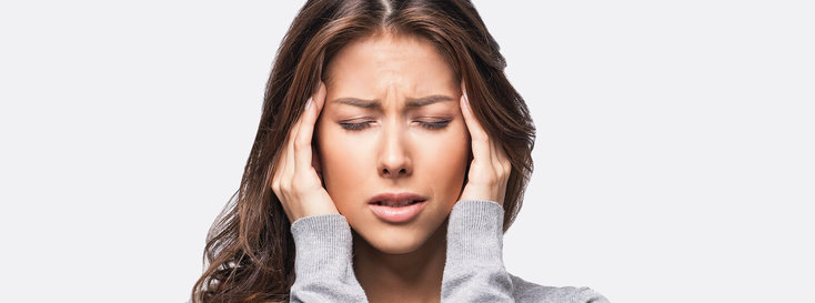 woman holding temples for migraine headache pain