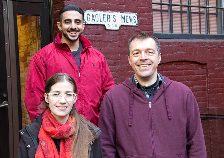 Three new OXD employees standing outside of the office
