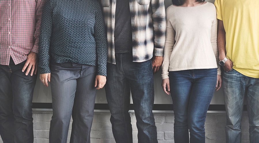 Five people standing in a row against the wall