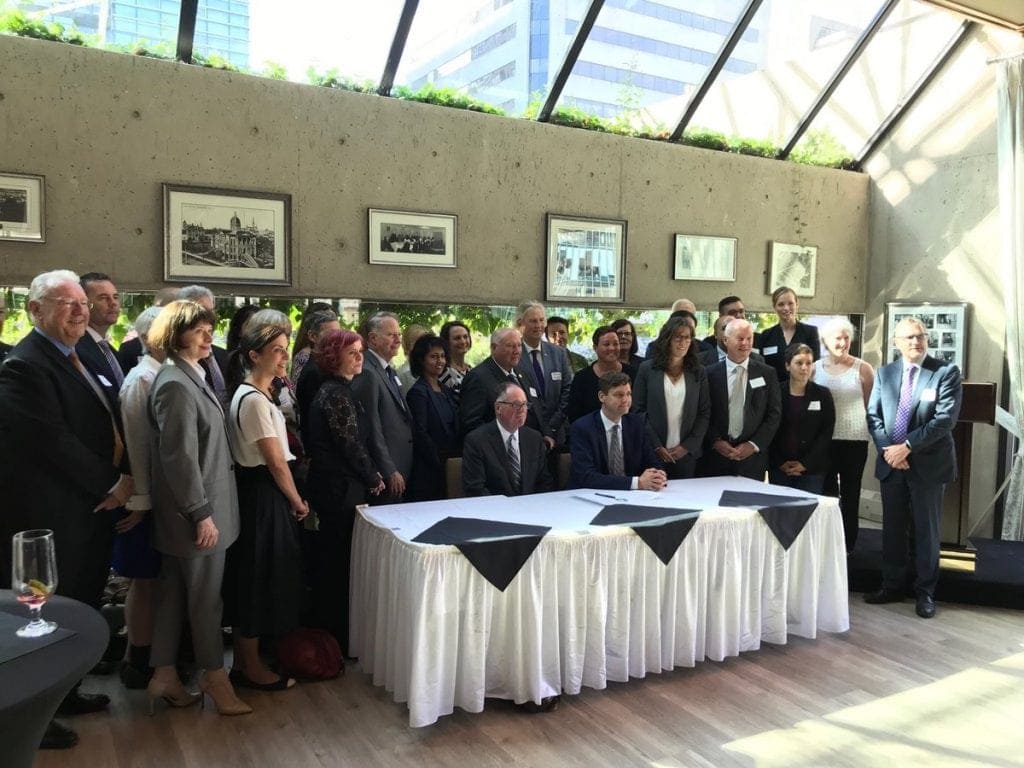 Photo of many people standing in a room for Access Justice BC Triple Arm 