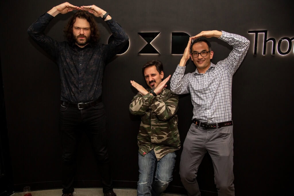 Photo of three OXD staff members making the OXD shapes with their arms