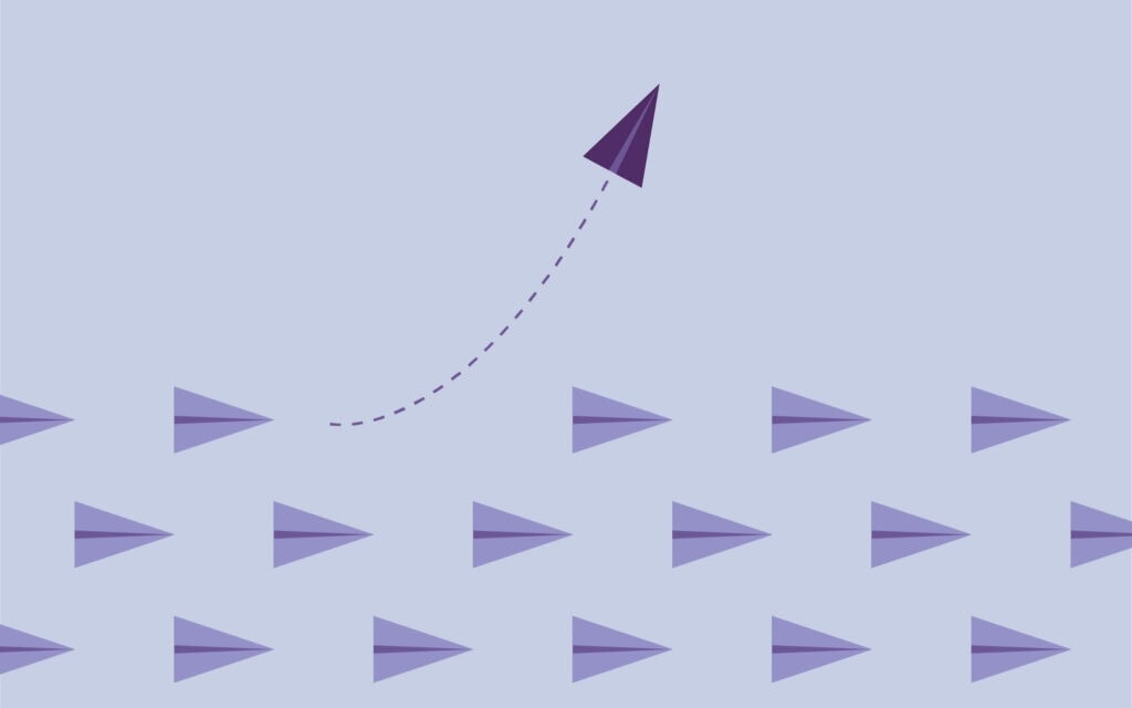 paper planes with one breaking away in shades of purple
