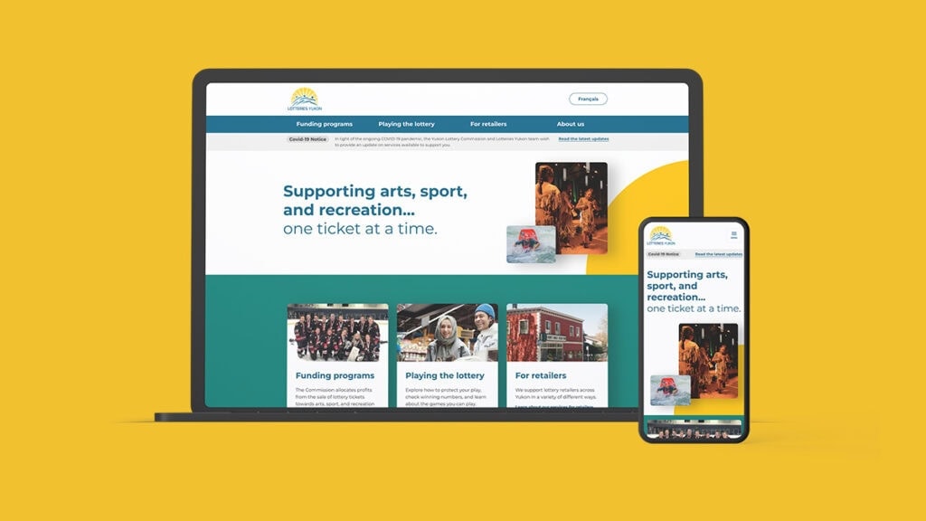 Lotteries Yukon redesign website home page on a clay laptop and iphone over a gold background