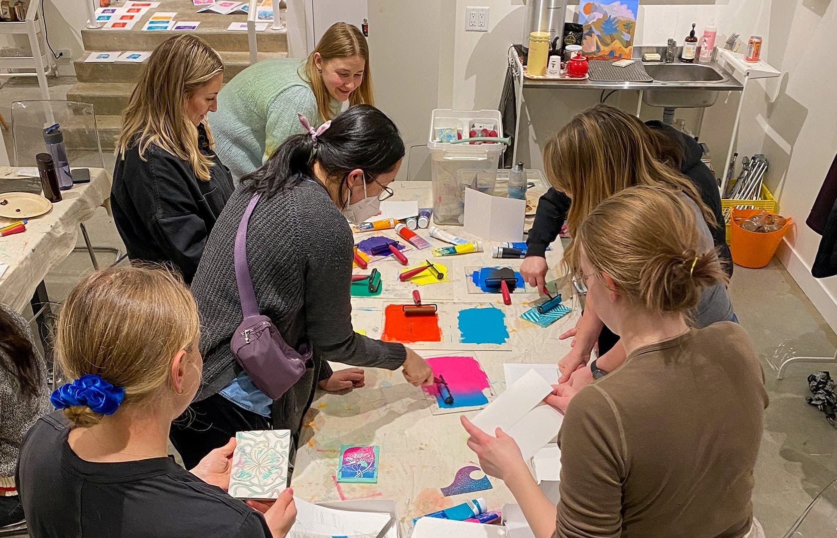 Group photo of OXD and ThoughtFarmer staff using the ink rollers to do their prints.