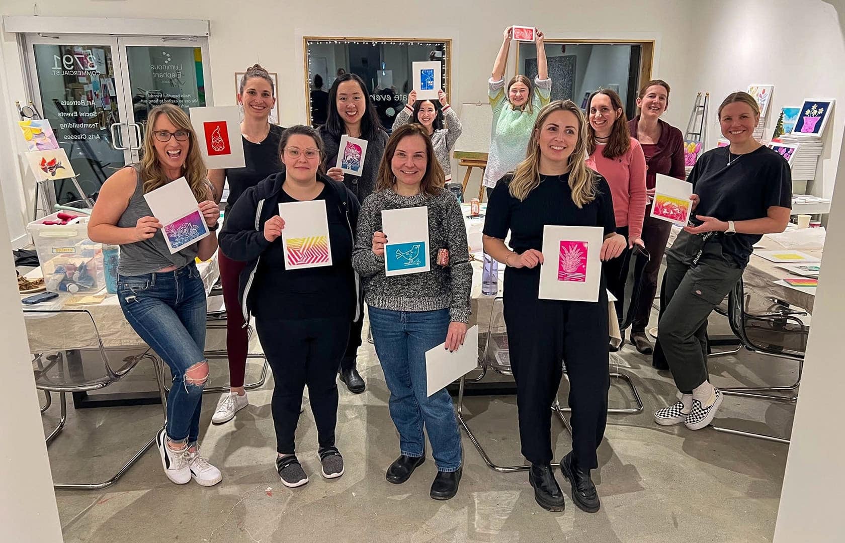 Group photo of the OXD and ThoughtFarmer staff holding up their finished prints and laughing and smiling