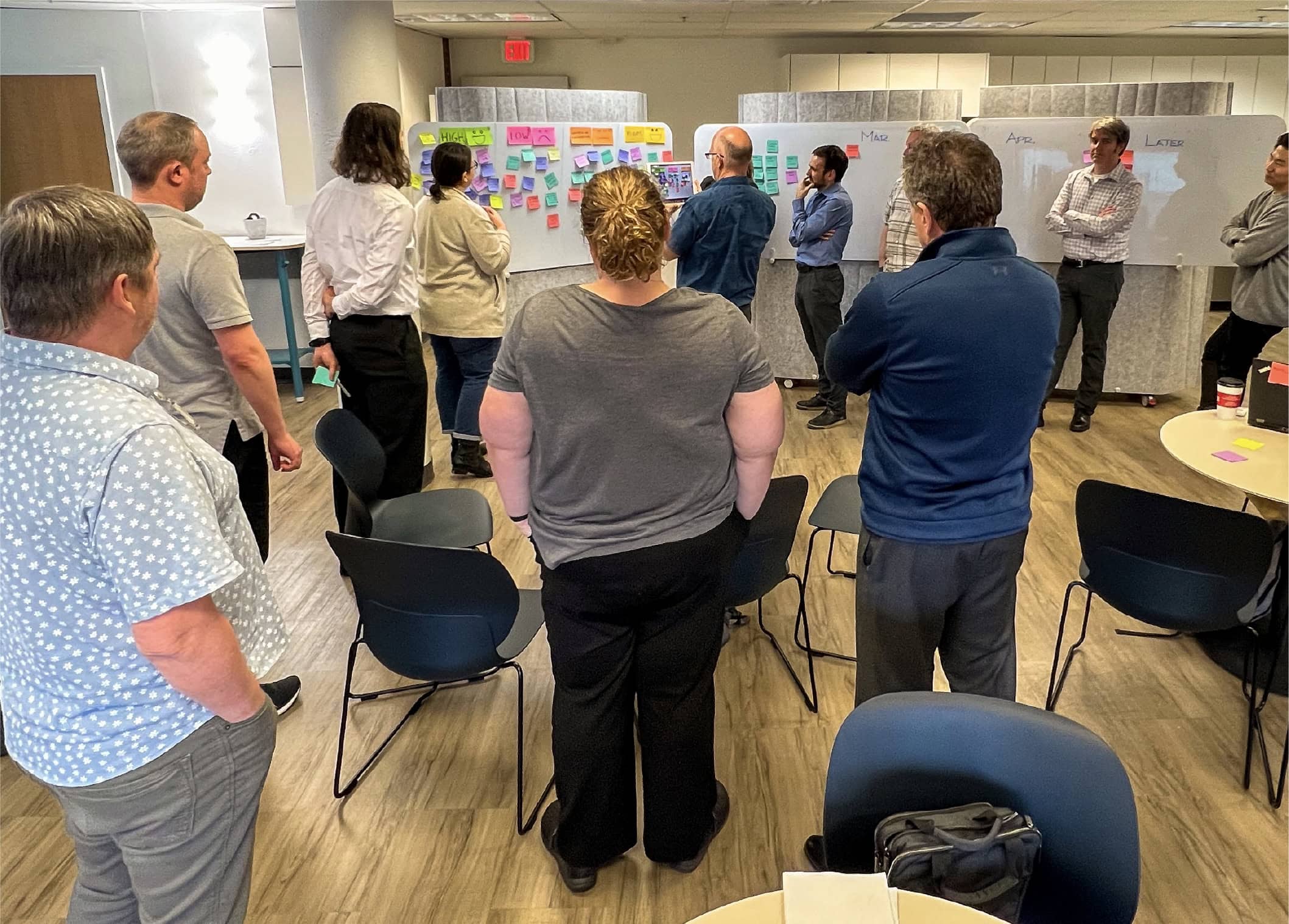 OXD and DriveBC team members standing in front of whiteboards covered in colourful sticky notes.