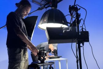 Behind-the-scenes shot of a video production setup with lighting and camera equipment Behind-the-scenes shot of a video production setup with lighting and camera equipment