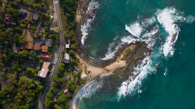 Stunning aerial view of Thangalla coastline with lush greenery and azure ocean waves.