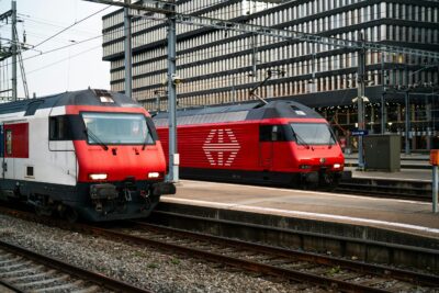 Two modern red trains at Zurich train station, early evening setting.